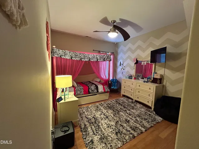 walk in closet with window and chandelier