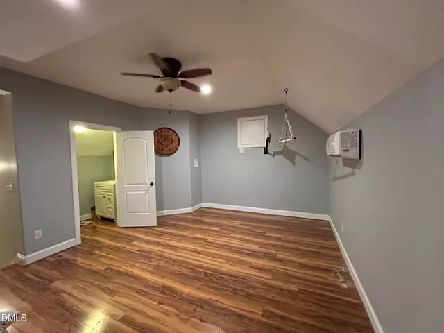 a view of a livingroom with a chandelier fan and wooden floor