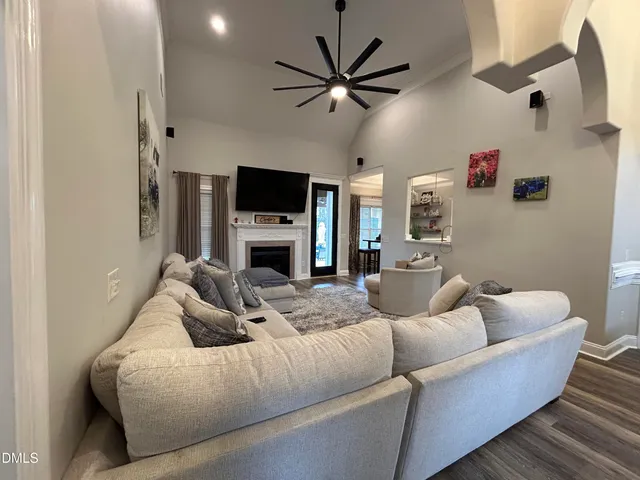 a living room with furniture a ceiling fan and a flat screen tv