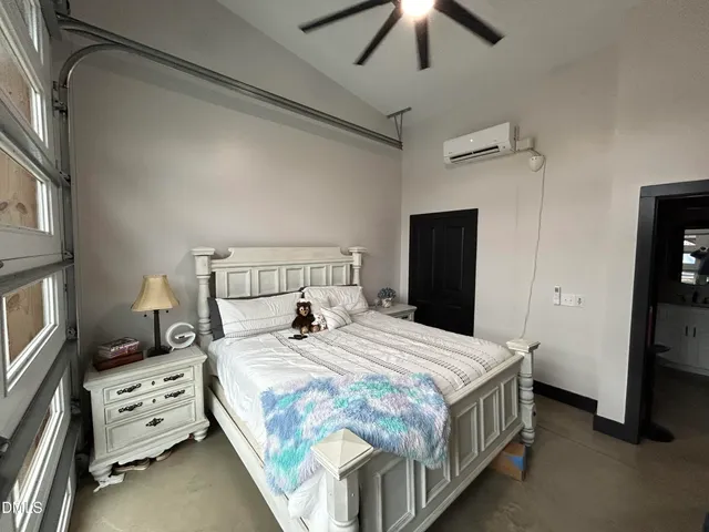 a bedroom with a bed a chandelier and a window