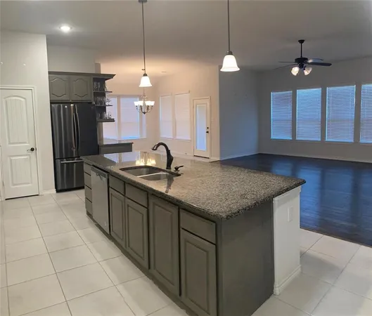 a kitchen with kitchen island granite countertop a sink a center island and stainless steel appliances