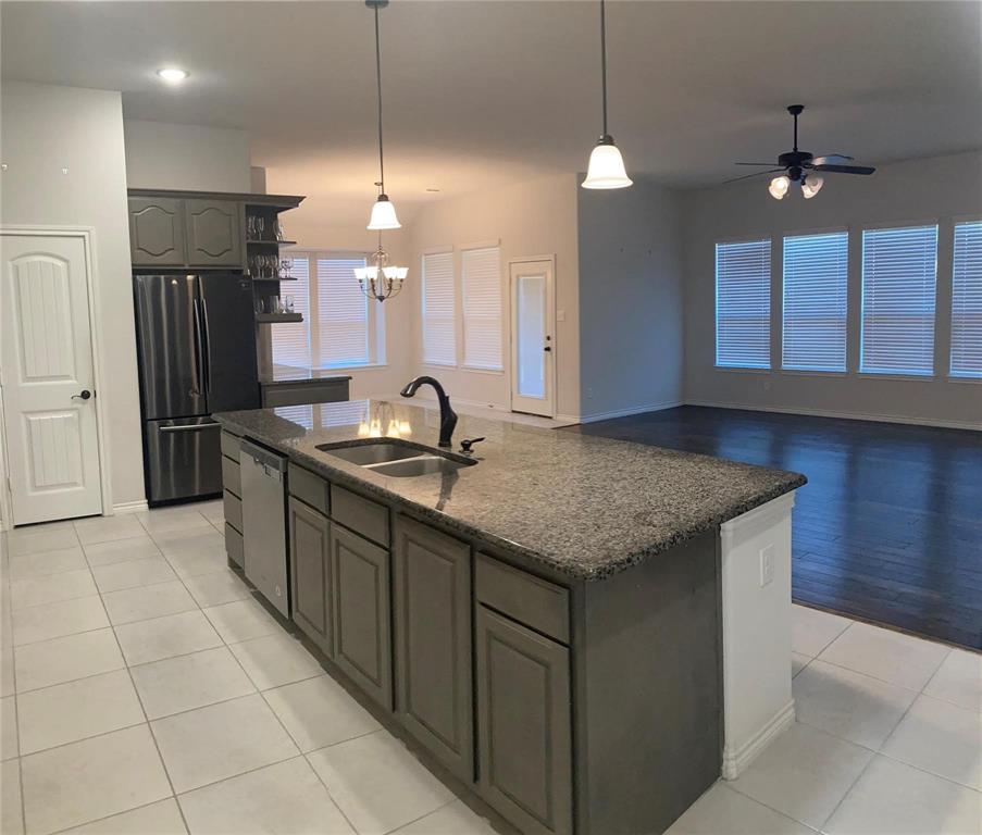 1566 Country Crest Drive Waxahachie, TX 75165 - Photo 5 of 12 a kitchen with kitchen island granite countertop a sink a center island and stainless steel appliances