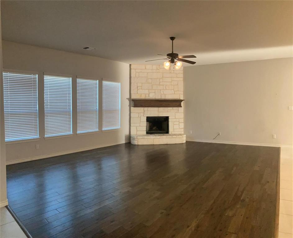 1566 Country Crest Drive Waxahachie, TX 75165 - Photo 6 of 12 an empty room with wooden floor fireplace and cabinet