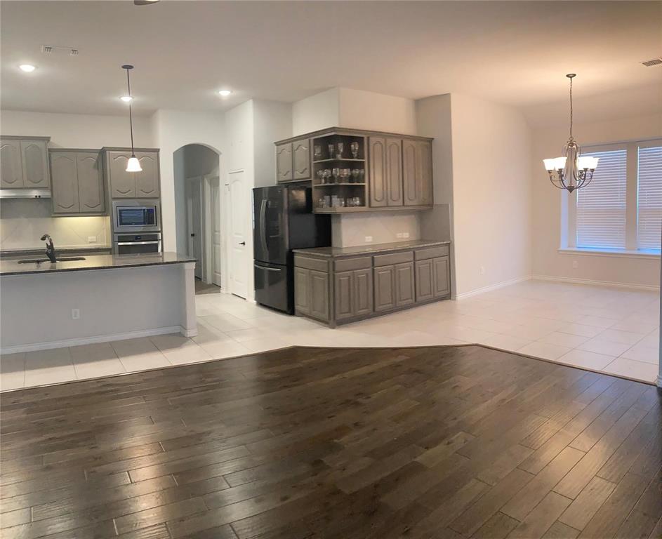 1566 Country Crest Drive Waxahachie, TX 75165 - Photo 8 of 12 a kitchen with stainless steel appliances granite countertop a refrigerator a sink dishwasher a oven and a large island with wooden floor