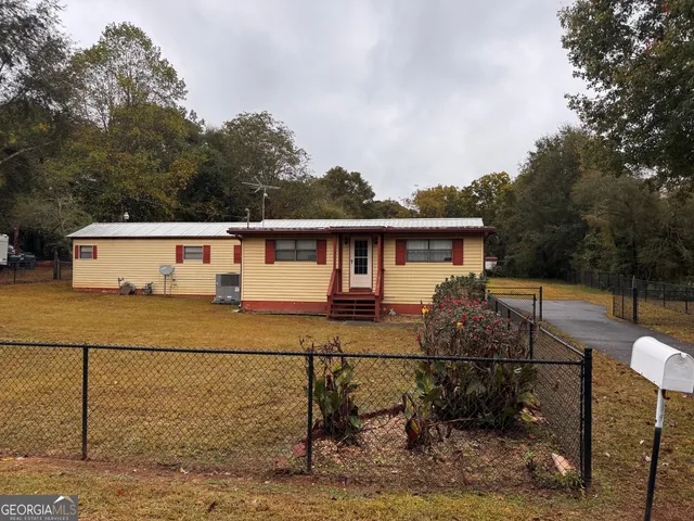 a view of house with backyard and sitting area