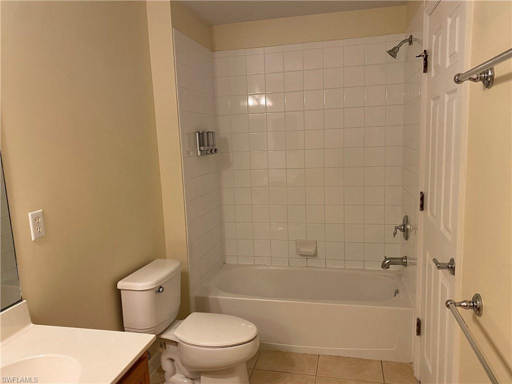 16162 Ravina Way, Unit 65 Naples, FL 34110 - Photo 10 of 12 a white toilet sitting next to a bath tub and a shower