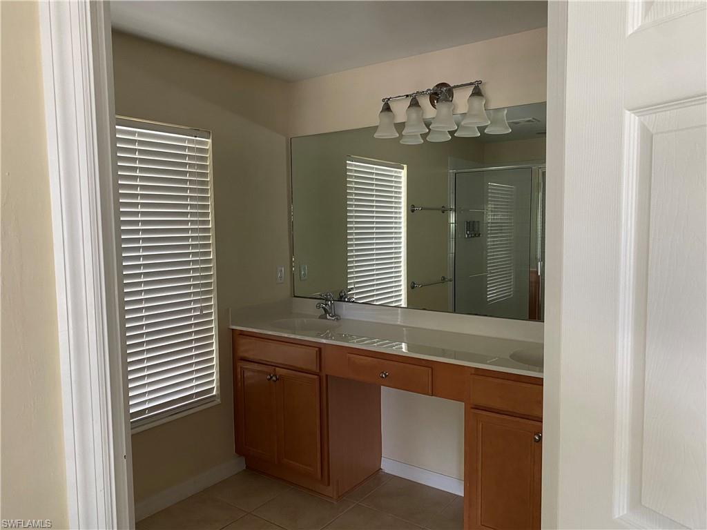 16162 Ravina Way, Unit 65 Naples, FL 34110 - Photo 8 of 12 a bathroom with a granite countertop sink and a mirror