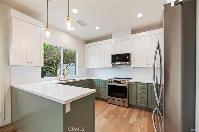 a kitchen with stainless steel appliances a stove sink microwave and refrigerator