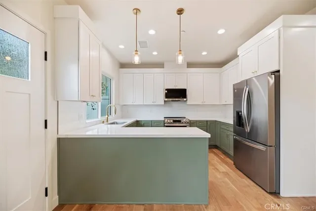 a kitchen with kitchen island a refrigerator a sink and a stove