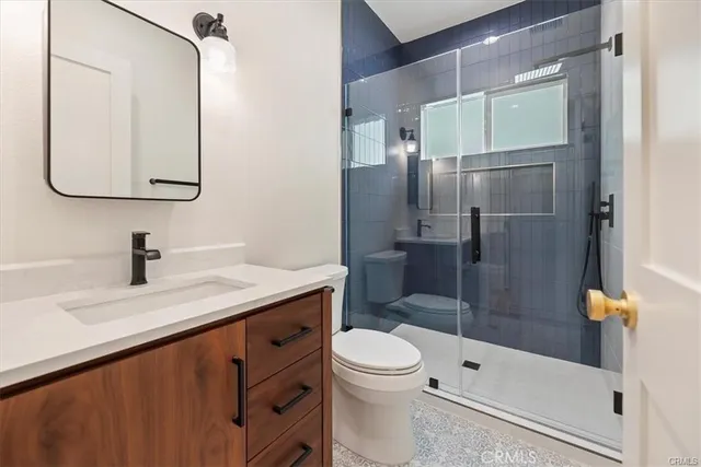 a bathroom with a granite countertop sink toilet and shower