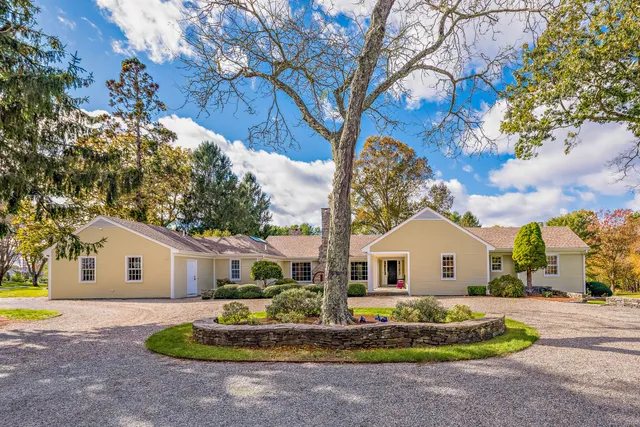 a view of house with backyard and trees