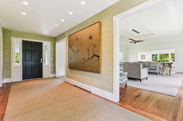 a view of a hallway with wooden floor and furniture