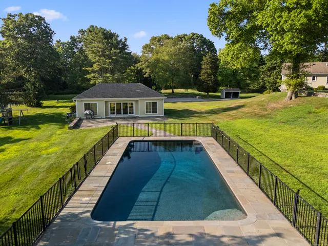 a view of an ocean with swimming pool and trees in the background