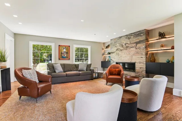 a living room with furniture fireplace and a large window