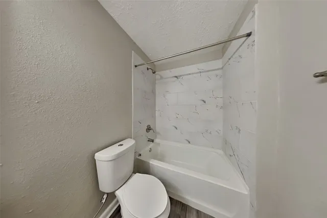 a white toilet sitting next to a bath tub