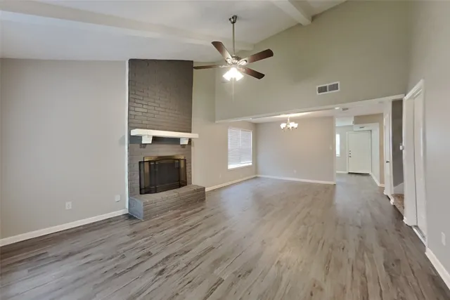 a view of a livingroom with wooden floor a ceiling fan and staircase