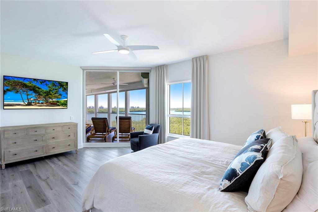 295 Grande Way, Unit 404 Naples, FL 34110 - Photo 11 of 27 a bed room with a bed couch and a window