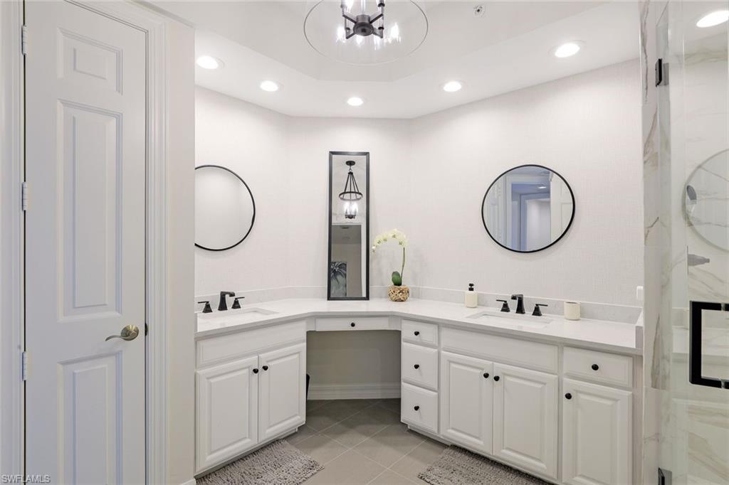 295 Grande Way, Unit 404 Naples, FL 34110 - Photo 12 of 27 a spacious bathroom with a double vanity sink double and a mirror