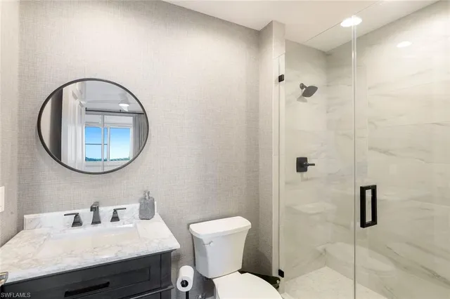 a bathroom with a toilet a sink and a mirror