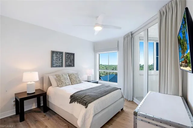 a bedroom with a bed lamp and a large window