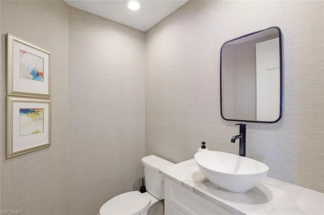 a bathroom with a toilet a sink and mirror