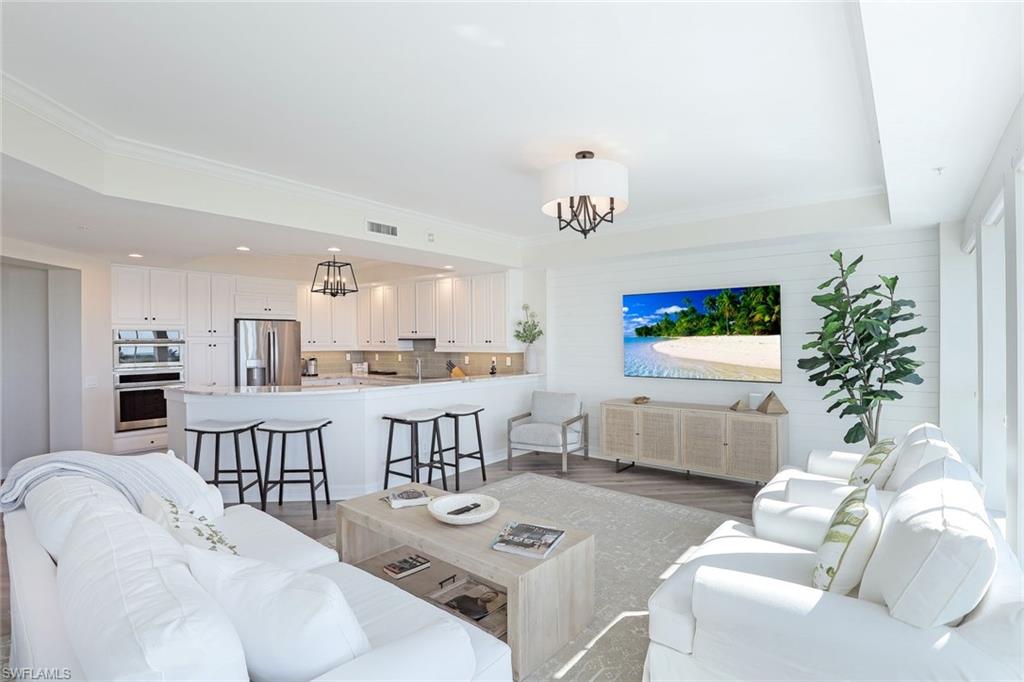 295 Grande Way, Unit 404 Naples, FL 34110 - Photo 3 of 27 a living room with furniture and a table