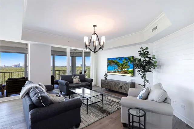 a living room with furniture a rug and a chandelier