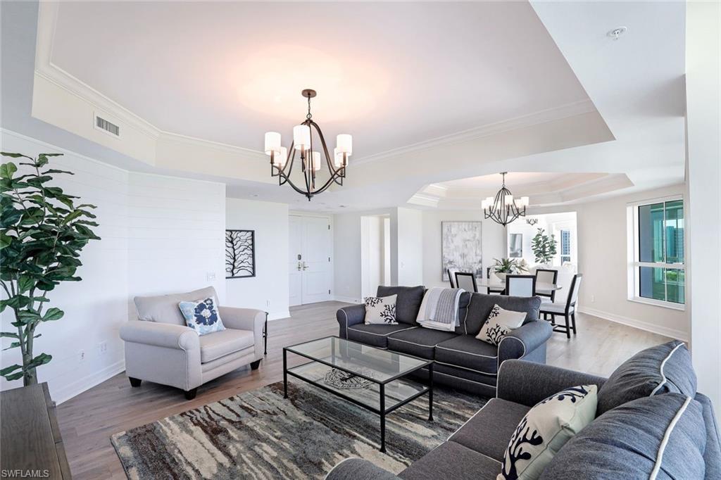 295 Grande Way, Unit 404 Naples, FL 34110 - Photo 5 of 27 a living room with furniture a chandelier and a chandelier