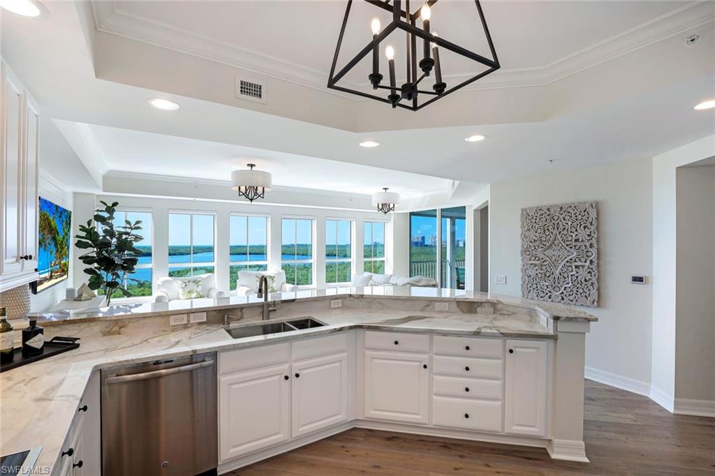 295 Grande Way, Unit 404 Naples, FL 34110 - Photo 6 of 27 a kitchen with granite countertop a sink stainless steel appliances and cabinets