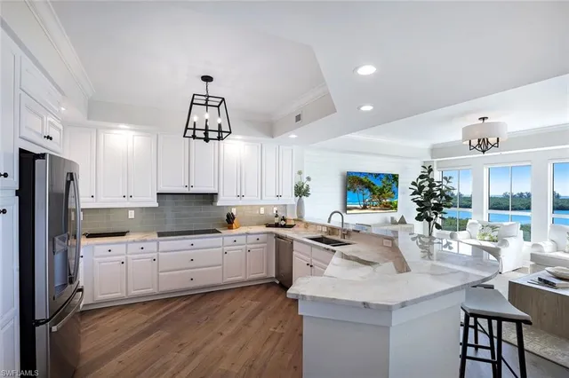 a kitchen with stainless steel appliances kitchen island granite countertop a sink cabinets and wooden floor