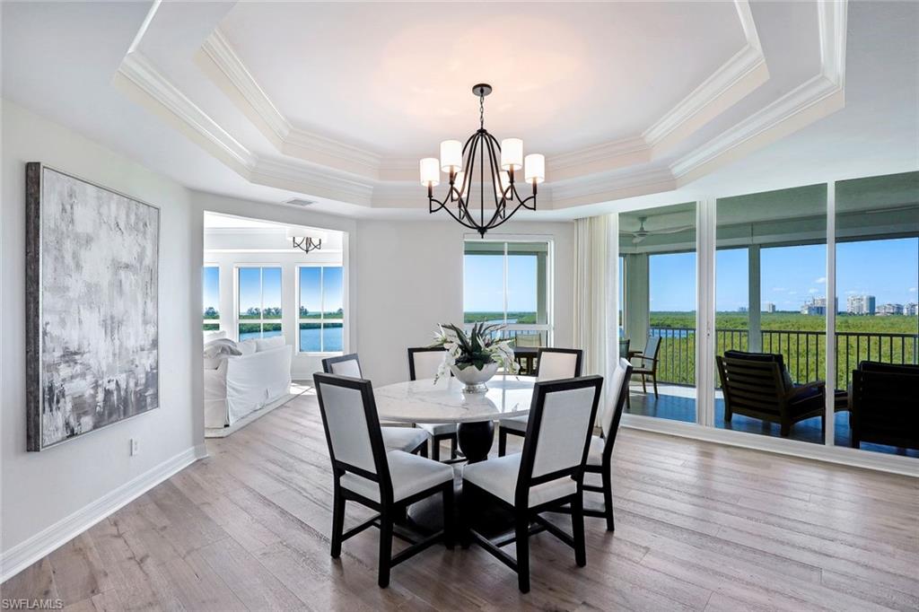 295 Grande Way, Unit 404 Naples, FL 34110 - Photo 9 of 27 a view of a dining room with furniture window and wooden floor