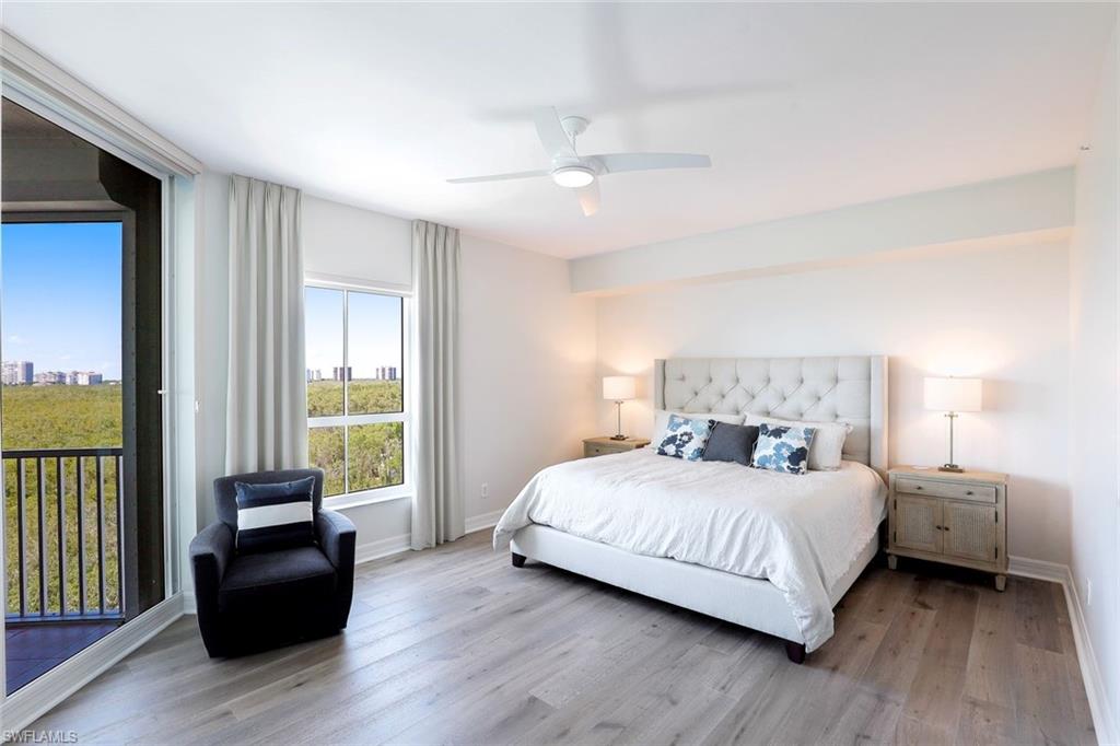 295 Grande Way, Unit 404 Naples, FL 34110 - Photo 10 of 27 a bedroom with a bed and a couch next to a window