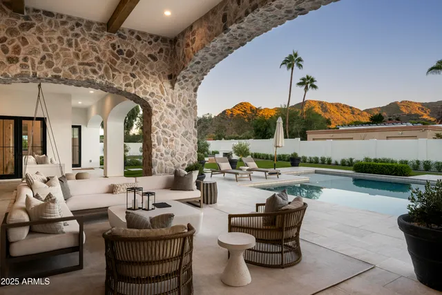 a living room with patio furniture and a swimming pool