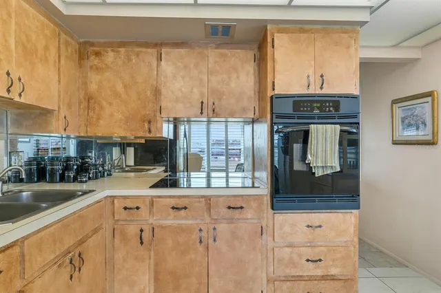 a kitchen with granite countertop a sink and a stove next to a window