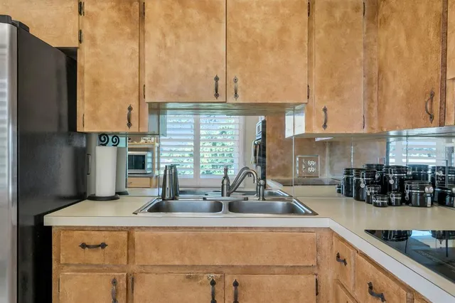 a kitchen with stainless steel appliances granite countertop a sink a refrigerator and cabinets