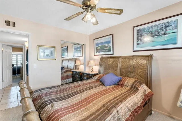 a bedroom with a bed and lamp painting on the wall