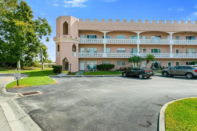 a front view of a building with a garden and plants