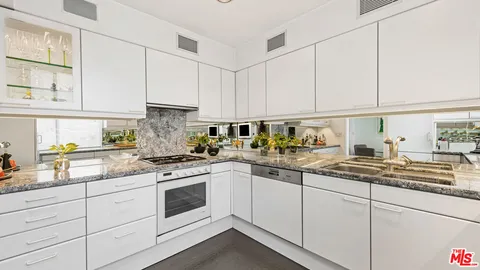 a kitchen with stainless steel appliances granite countertop white cabinets a sink and dishwasher