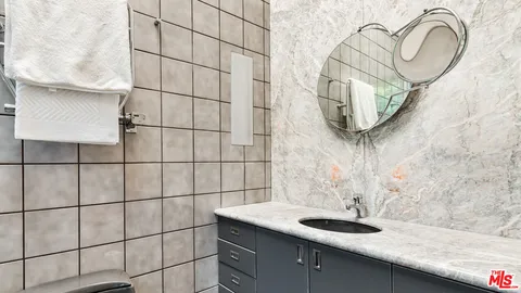 a bathroom with a granite countertop sink a mirror and shower