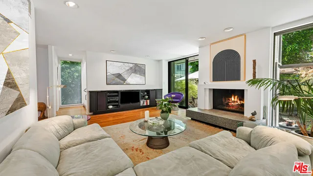 a living room with furniture a fireplace and a large window