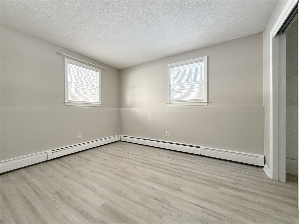 5 Meisner Circle, Unit 25 Salem, NH 03079 - Photo 4 of 6 an empty room with wooden floor and windows