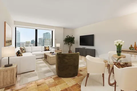 a living room with couches a coffee table and a flat screen tv