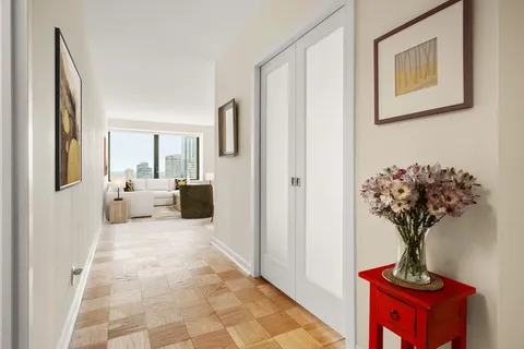 a view of a hallway with a flower pot and a bookshelf