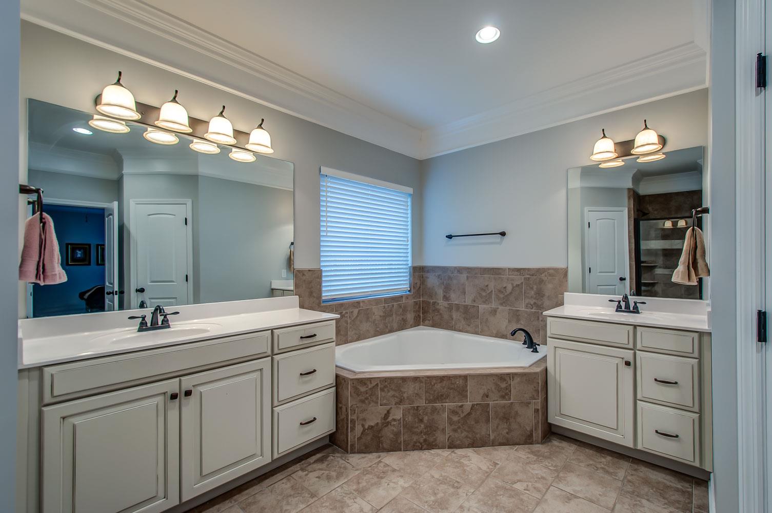 239 Abbey Road Lebanon, TN 37090 - Photo 14 of 25 a bathroom with a bathtub a double vanity sink and a mirror