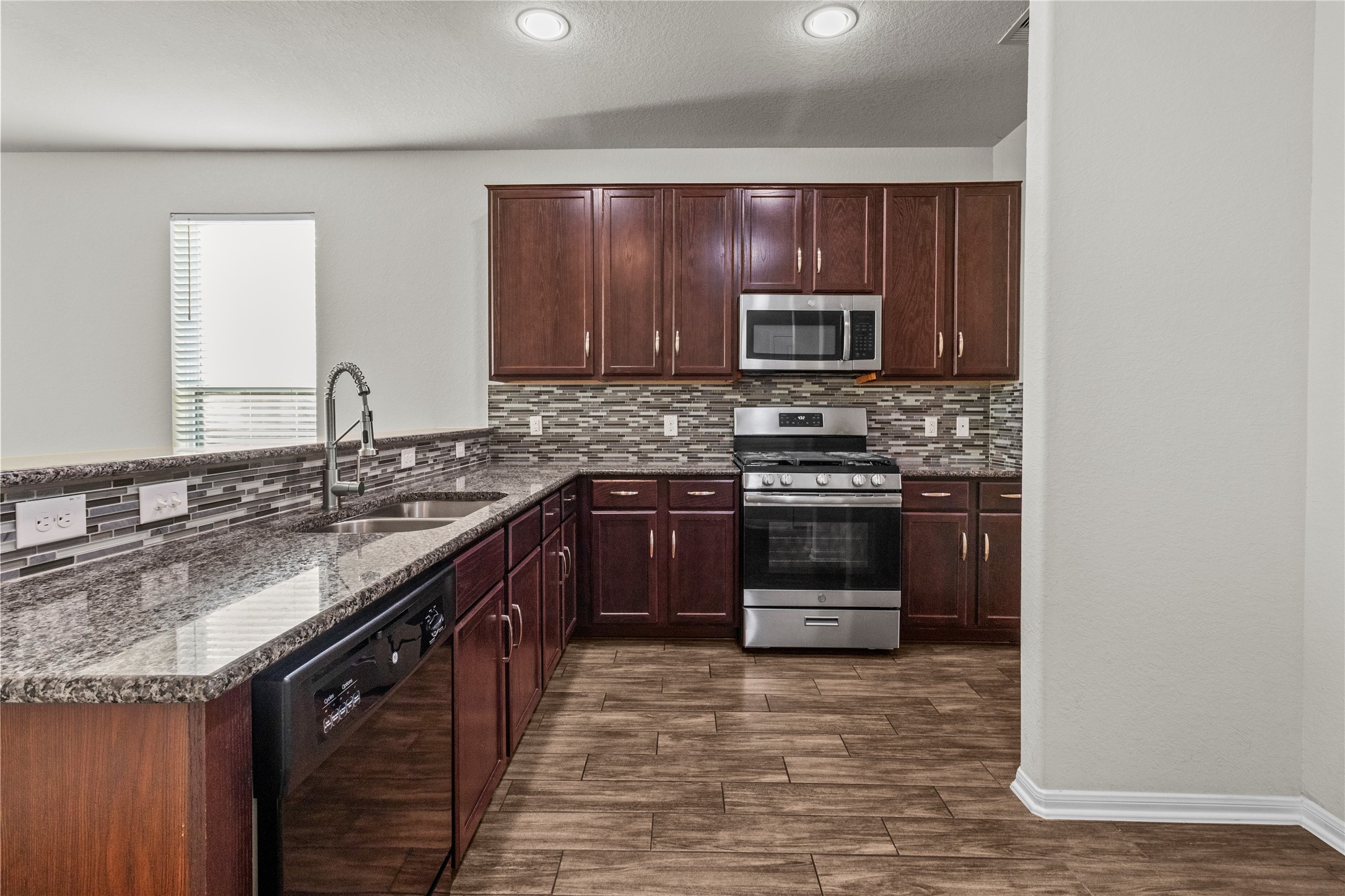 14610 Ruddy Duck Lane Houston, TX 77049 - Photo 9 of 24 a kitchen with a stove microwave and sink