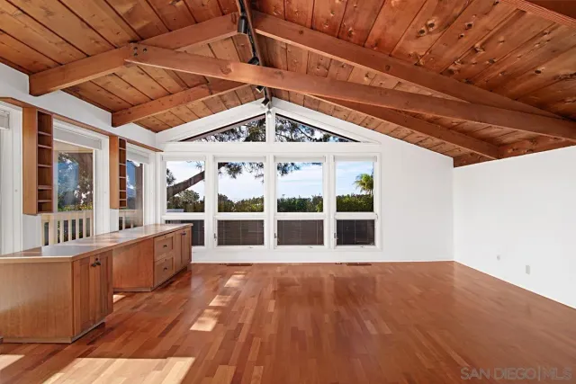 a view of a large room with wooden floor and balcony