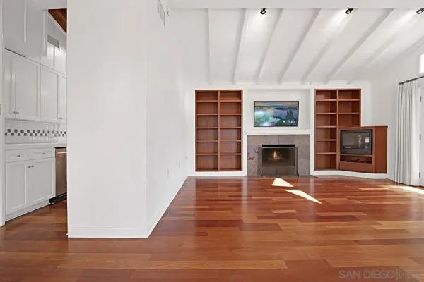 a view of a livingroom with wooden floor and a fireplace
