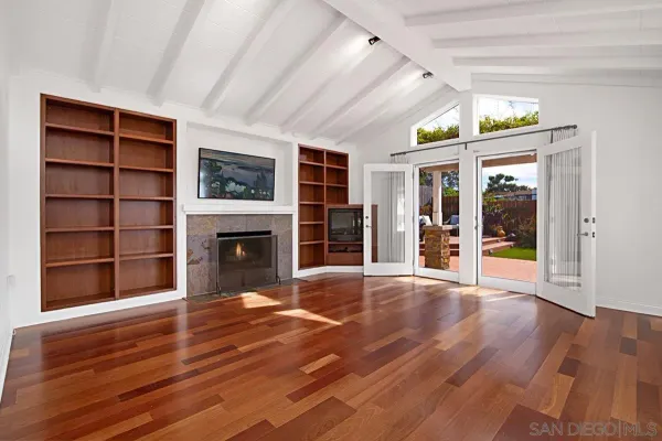 a view of an empty room with a fireplace and a window