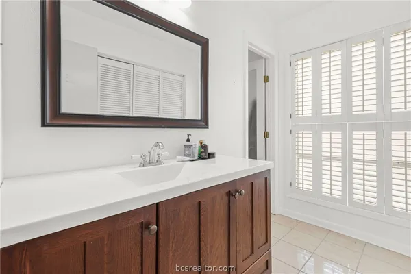 a bathroom with a sink a vanity and a large mirror