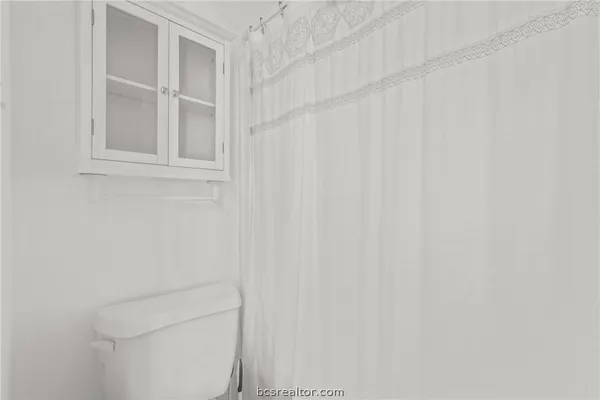 a white toilet sitting next to a shower